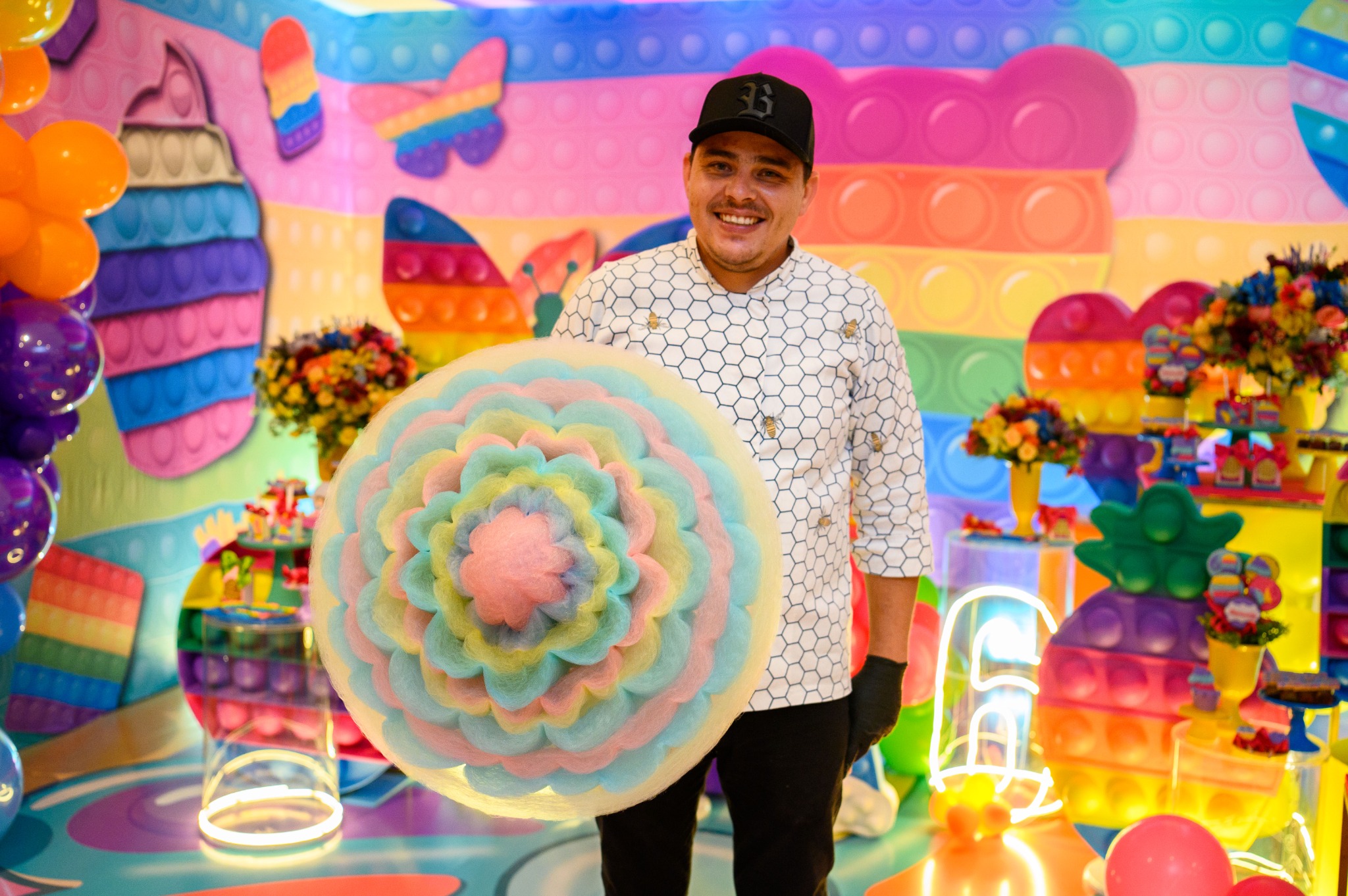 Alírio Ribeiro apresentando uma grande flor colorida de algodão-doce artístico
